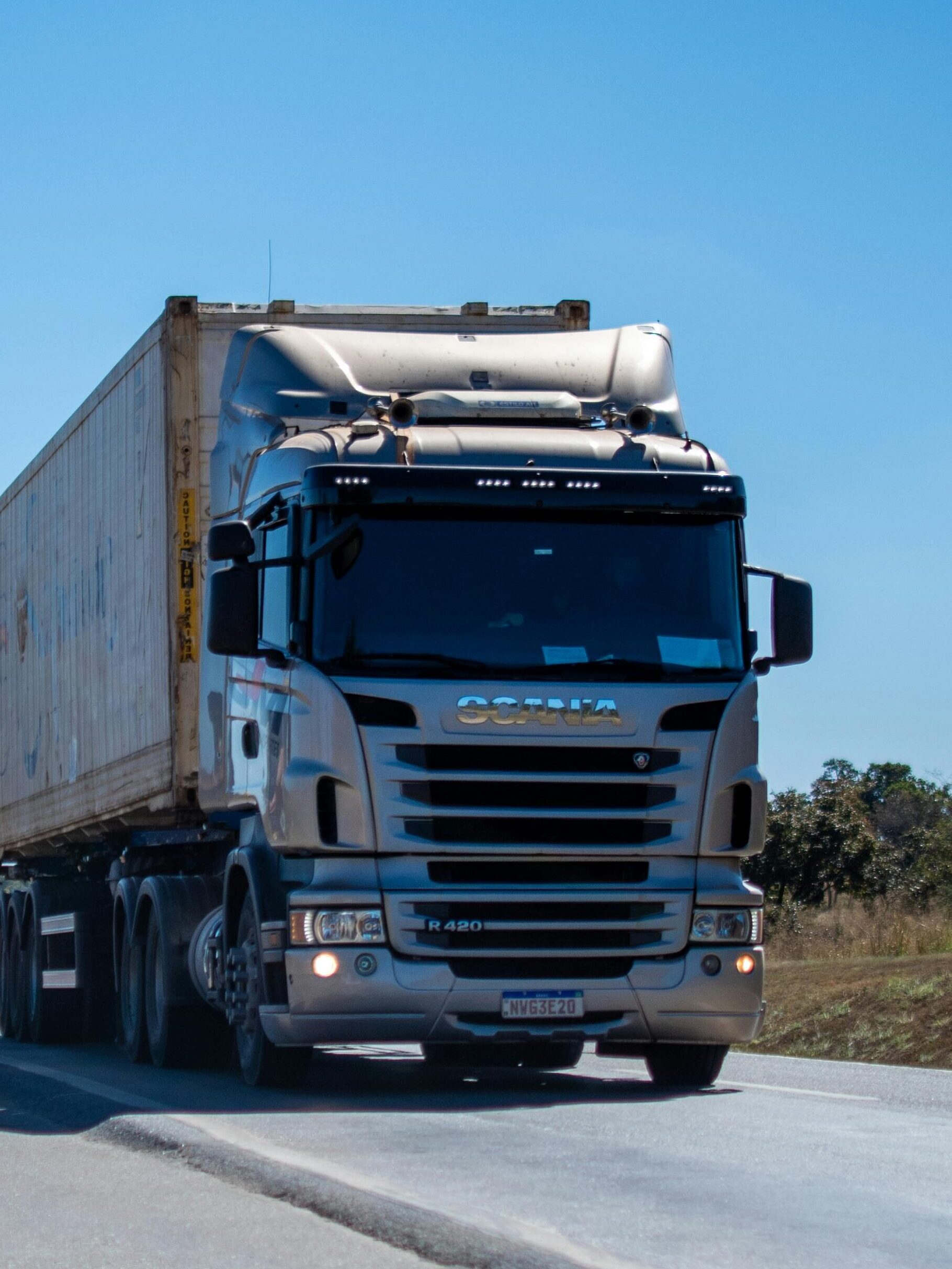 Home A large cargo truck travels on a highway in Brazil under clear blue skies.